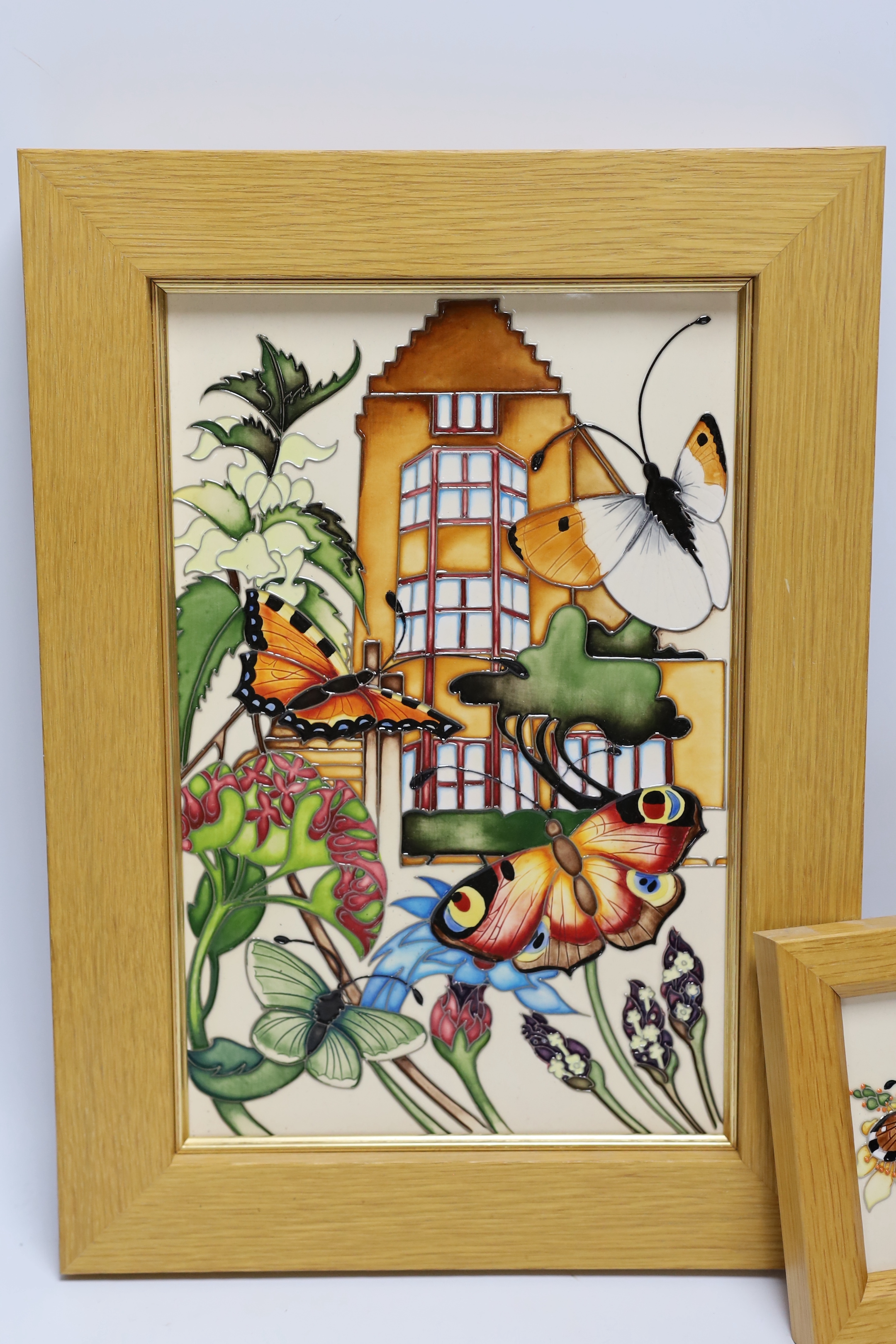 A Moorcroft Rachel Bishop wall plaque of butterflies and a similar smaller plaque, both in oak frames, largest 38 x 28cm